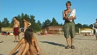 A Stunning Young Girl Disrobes And Frolics In The Ocean On A Sunny Beach